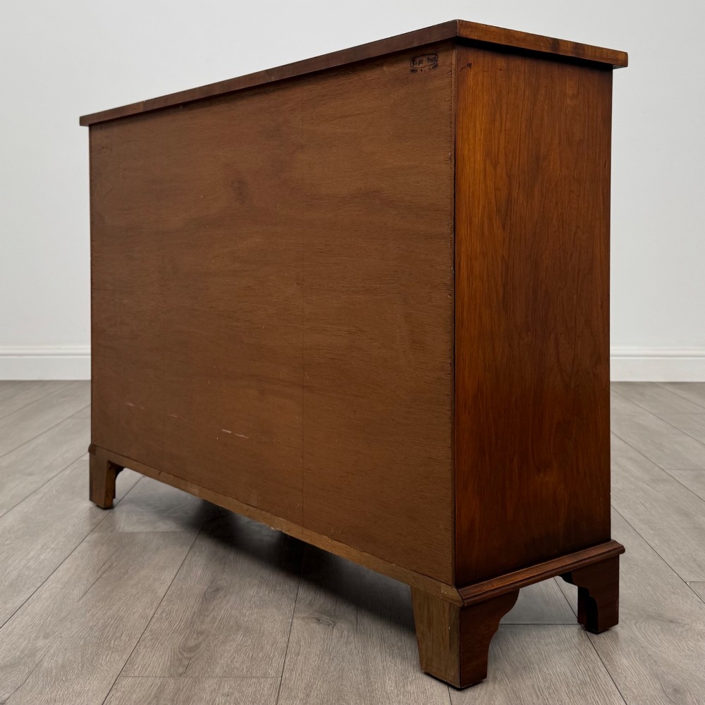 An antique 20th-century small breakfront sideboard with figured burr walnut veneers, brass drop handles, four central drawers, and side cupboard doors. View VII