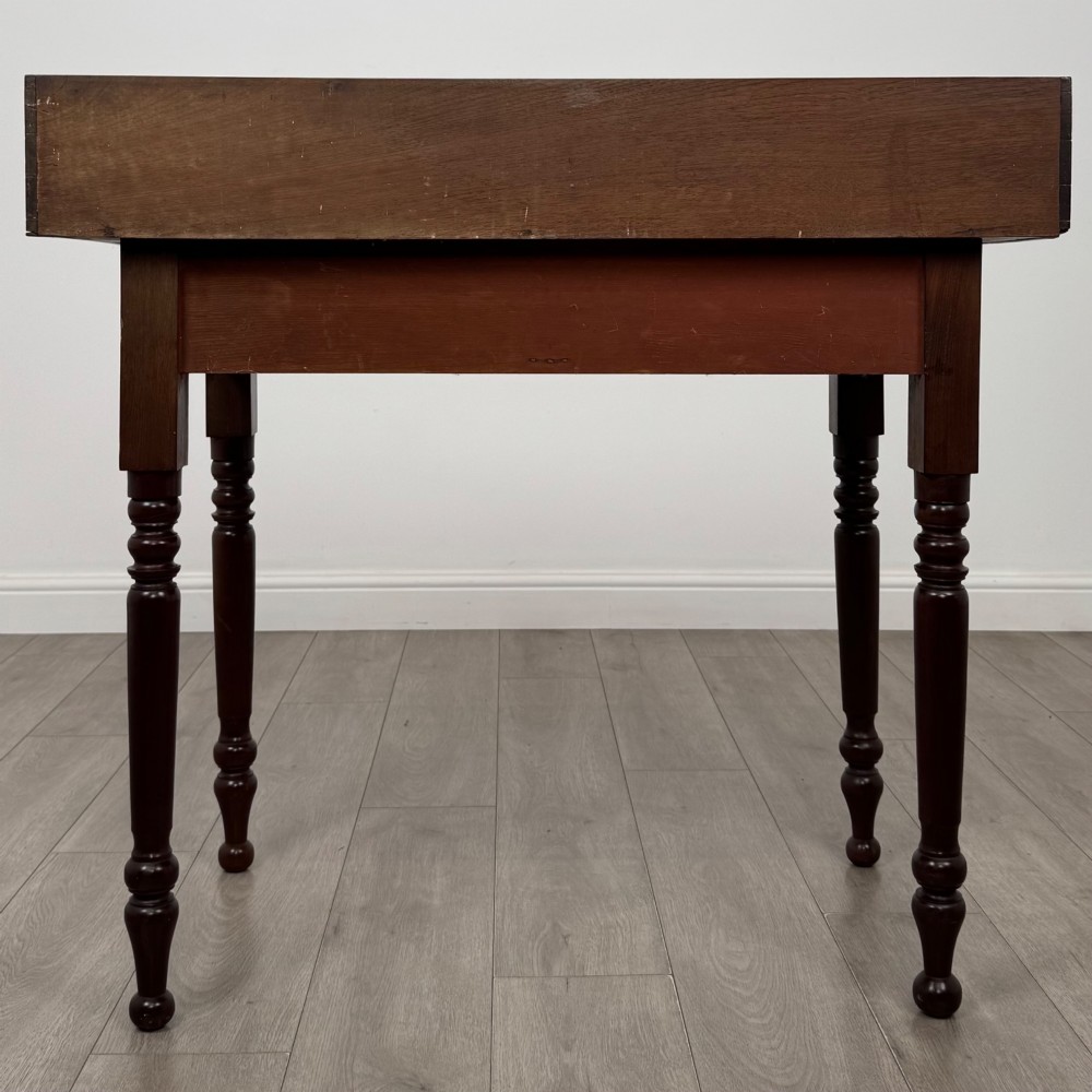 A 19th-century dark mahogany writing table featuring a raised gallery back upstand, two frieze drawers with turned handles, and four turned legs. View V