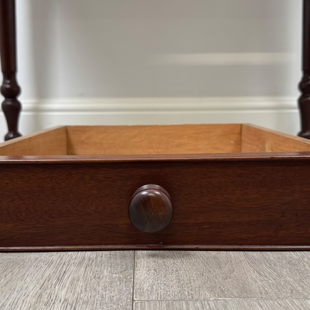 A 19th-century dark mahogany writing table featuring a raised gallery back upstand, two frieze drawers with turned handles, and four turned legs. View XI