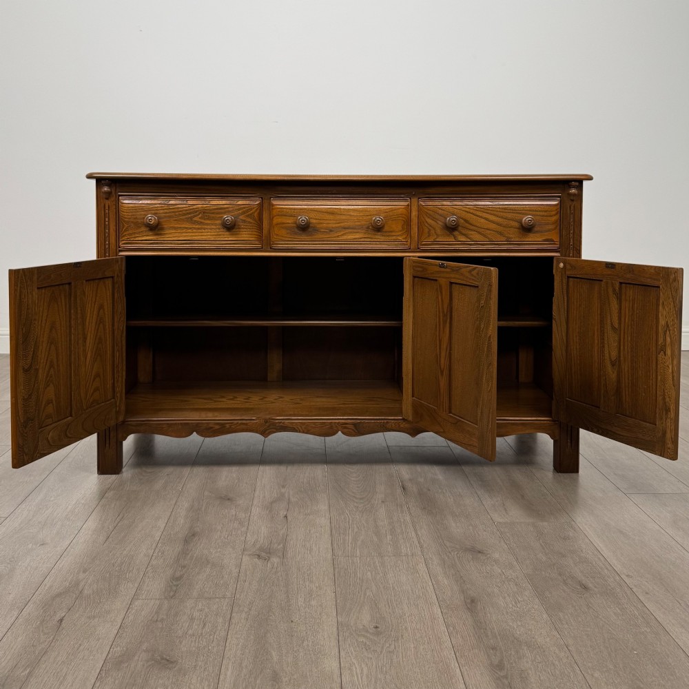 A warm brown solid oak sideboard with three drawers positioned above three fielded panel cupboard doors. View II