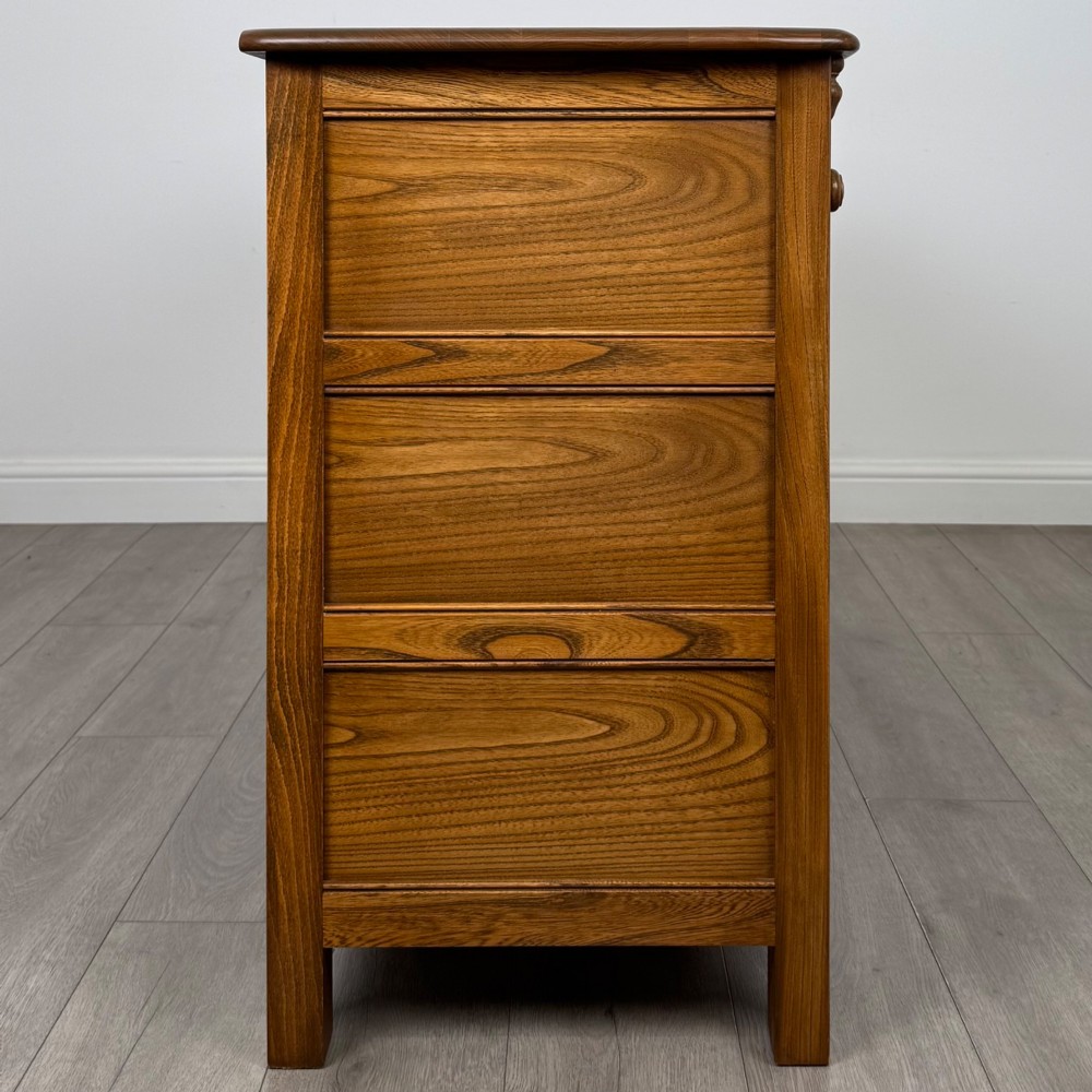 A warm brown solid oak sideboard with three drawers positioned above three fielded panel cupboard doors. View VIII