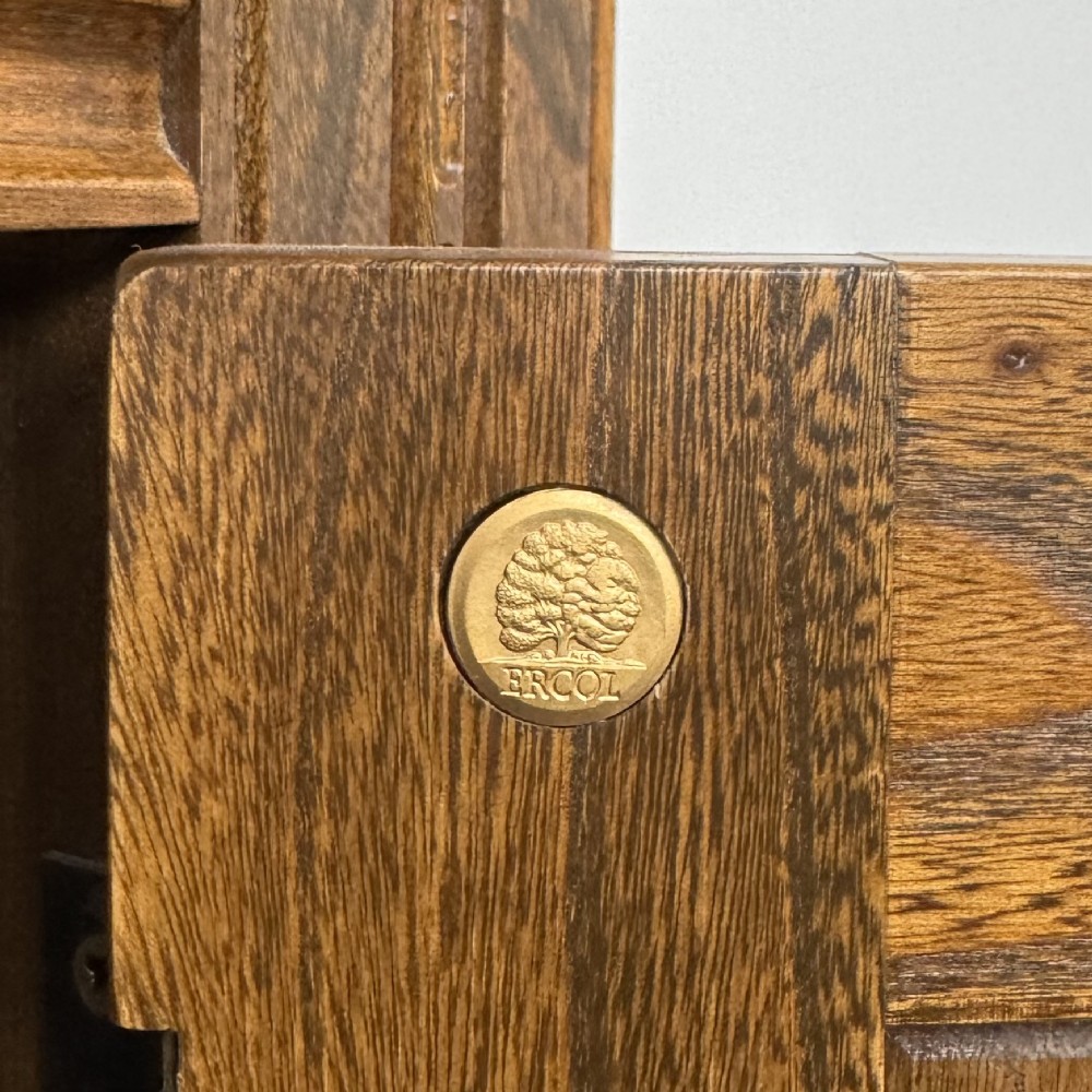 A warm brown solid oak sideboard with three drawers positioned above three fielded panel cupboard doors. View XIV