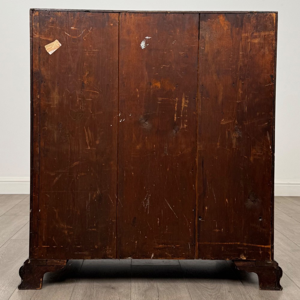 An 18th-century Georgian mahogany bureau featuring a sloped fall-front lid, brass batwing handles and escutcheons, three graduated drawers, and bracket feet. View VI