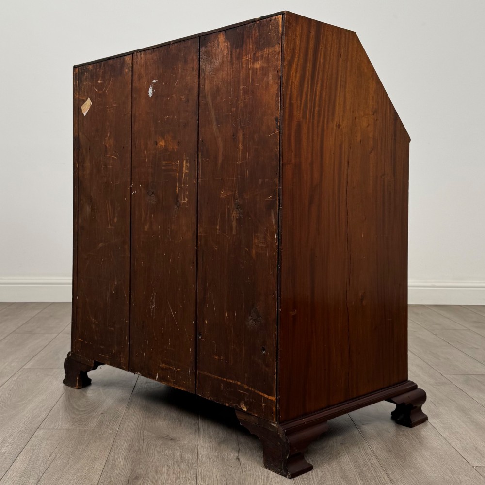 An 18th-century Georgian mahogany bureau featuring a sloped fall-front lid, brass batwing handles and escutcheons, three graduated drawers, and bracket feet. View VII