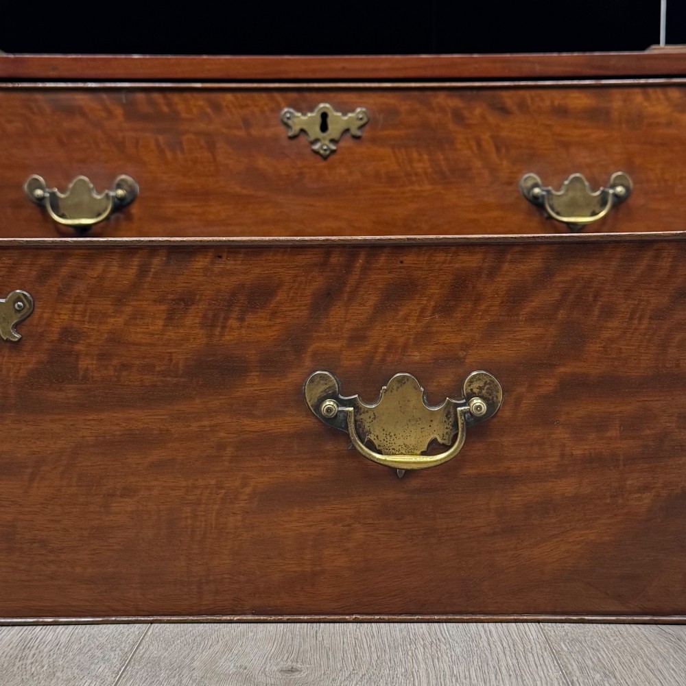 An 18th-century Georgian mahogany bureau featuring a sloped fall-front lid, brass batwing handles and escutcheons, three graduated drawers, and bracket feet. View XIII