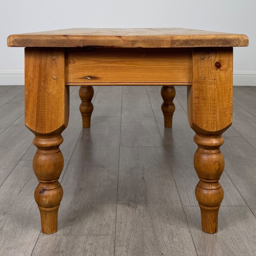 A low rectangular pine coffee table featuring turned baluster legs and visible wooden grain across its solid tabletop. View III