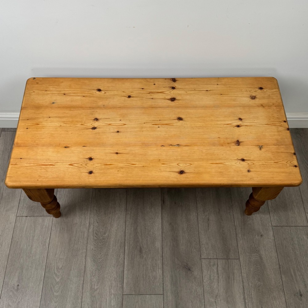 A low rectangular pine coffee table featuring turned baluster legs and visible wooden grain across its solid tabletop. View IX