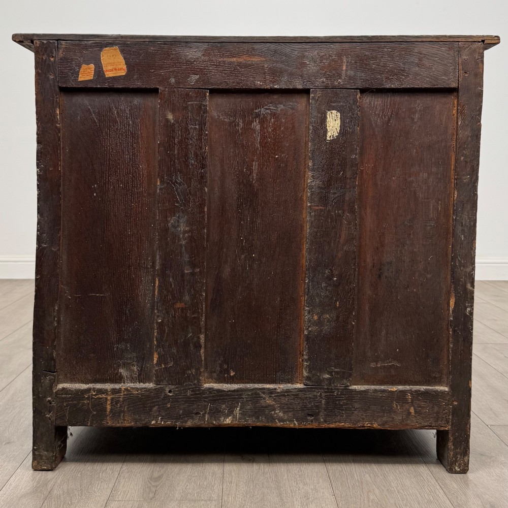A seventeenth-century oak cupboard featuring two panelled doors with moulded trim and hand-forged iron hinges. View VI