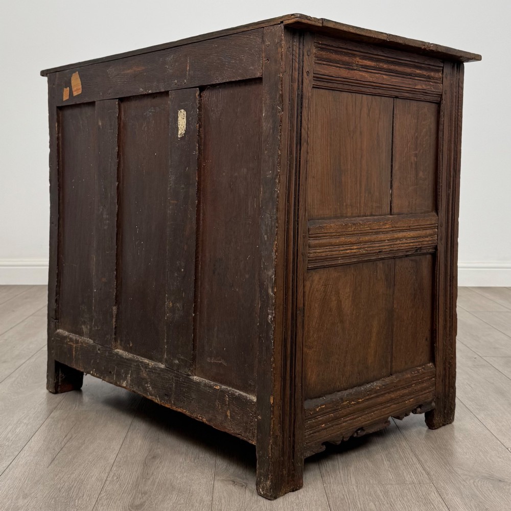 A seventeenth-century oak cupboard featuring two panelled doors with moulded trim and hand-forged iron hinges. View VII