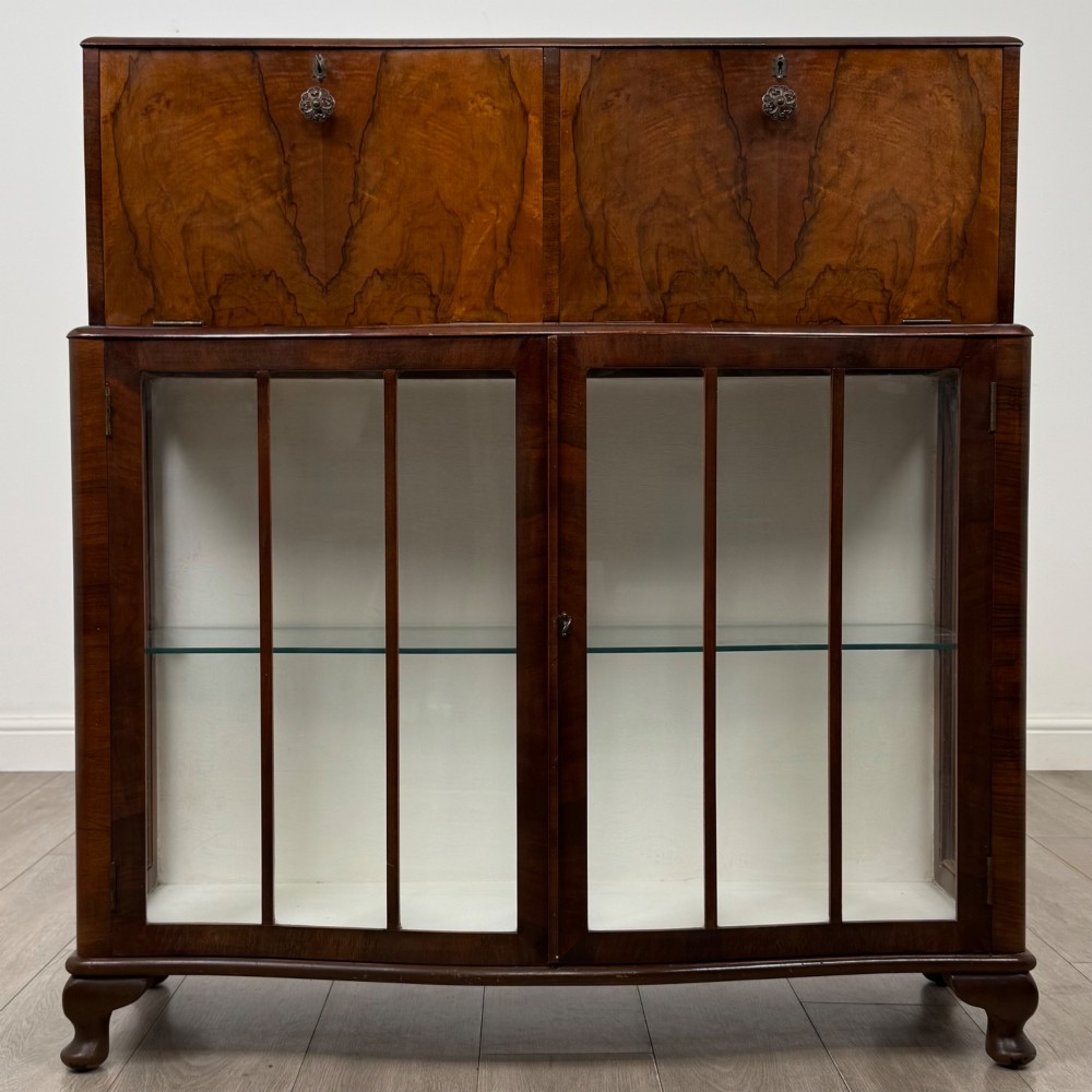 A 20th-century figured walnut fitted cabinet featuring upper solid doors above lower glazed doors with glass shelving.