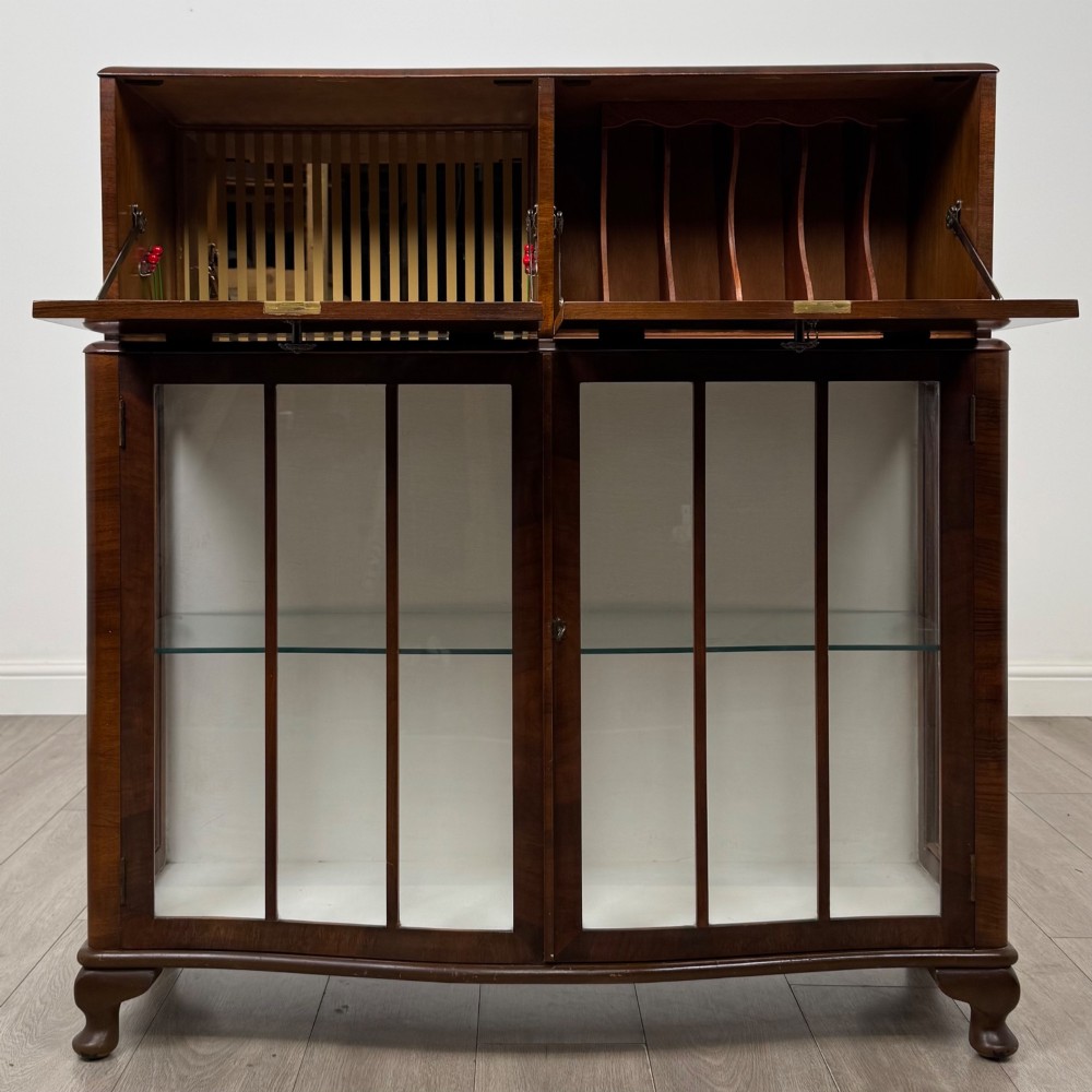 A 20th-century figured walnut fitted cabinet featuring upper solid doors above lower glazed doors with glass shelving. View II