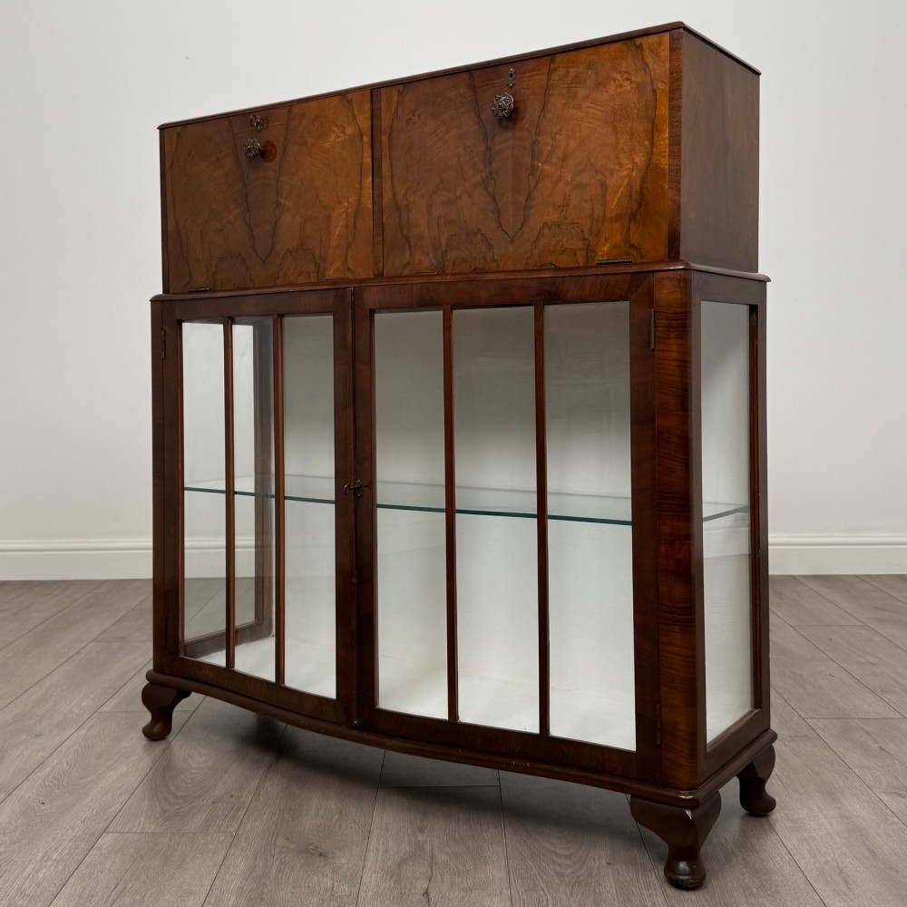 A 20th-century figured walnut fitted cabinet featuring upper solid doors above lower glazed doors with glass shelving. View IV