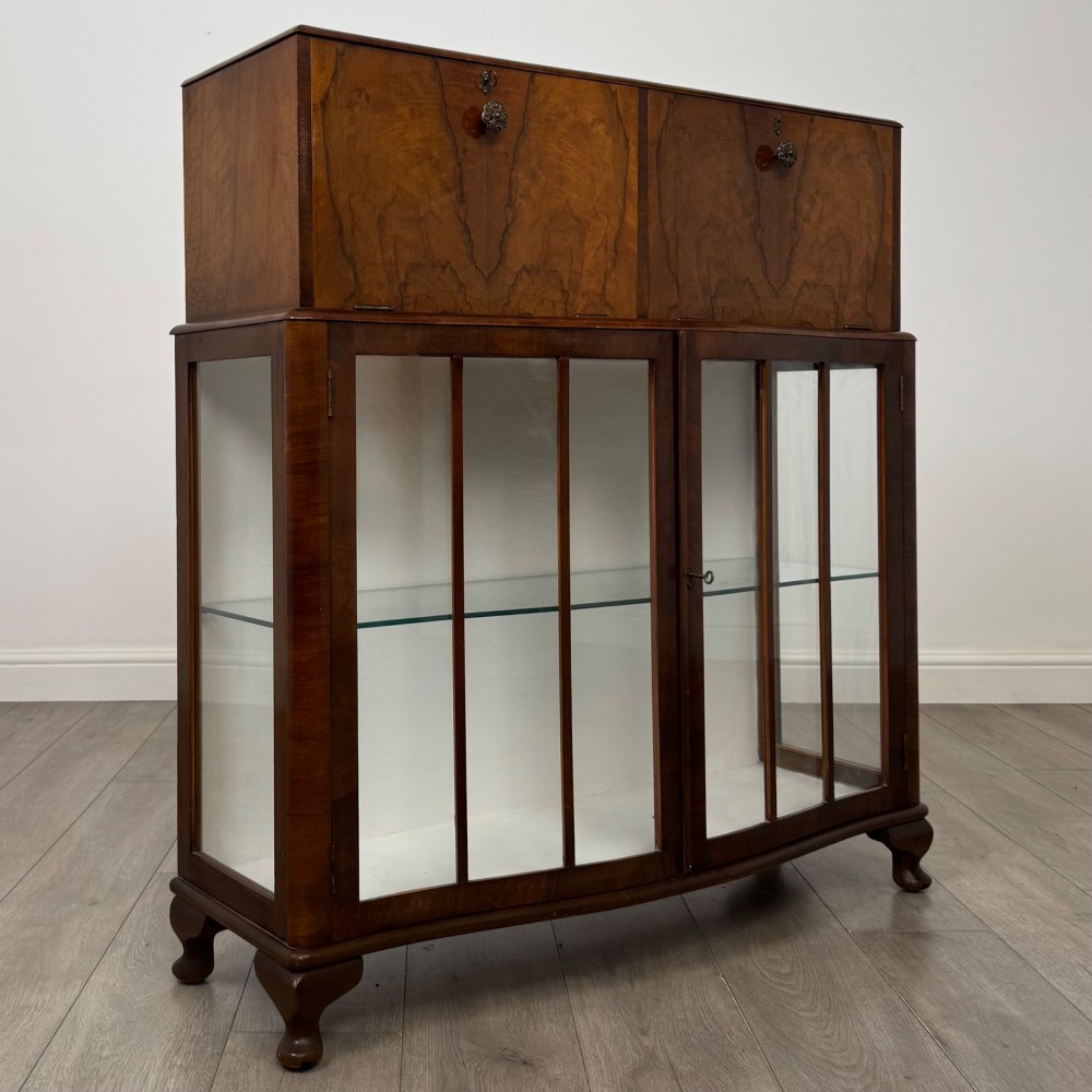 A 20th-century figured walnut fitted cabinet featuring upper solid doors above lower glazed doors with glass shelving. View VIII