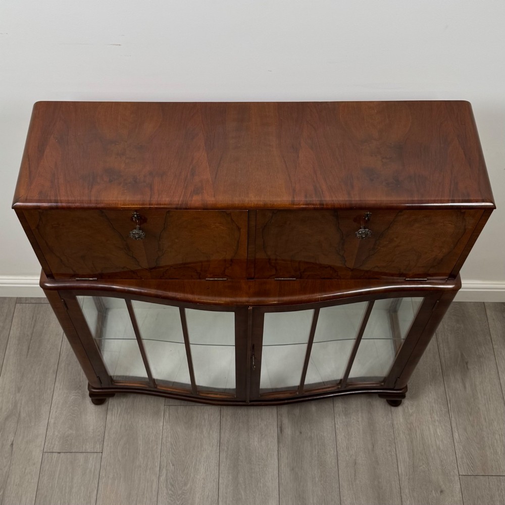 A 20th-century figured walnut fitted cabinet featuring upper solid doors above lower glazed doors with glass shelving. View IX