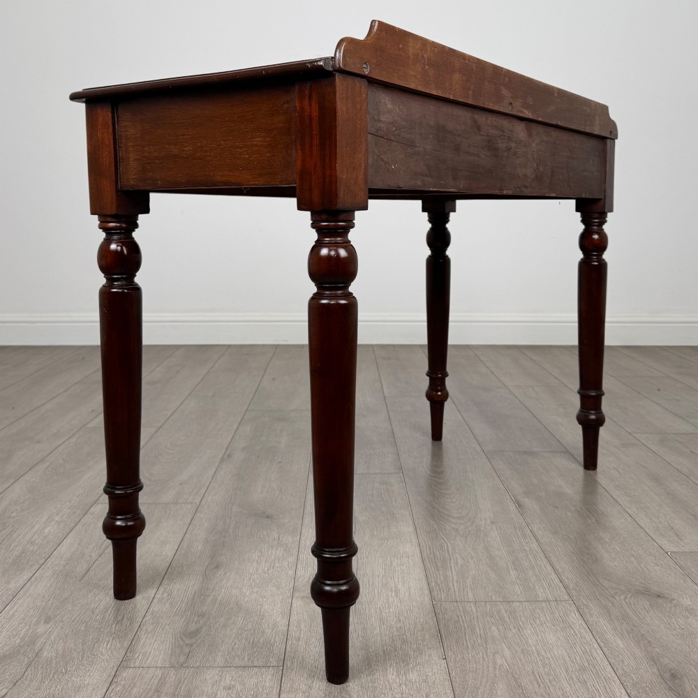 A Victorian mahogany writing table featuring two frieze drawers with brass ring handles and four turned legs. View IV