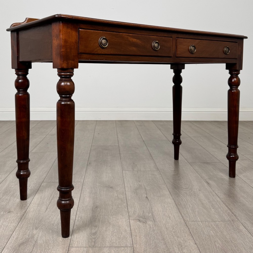 A Victorian mahogany writing table featuring two frieze drawers with brass ring handles and four turned legs. View VIII