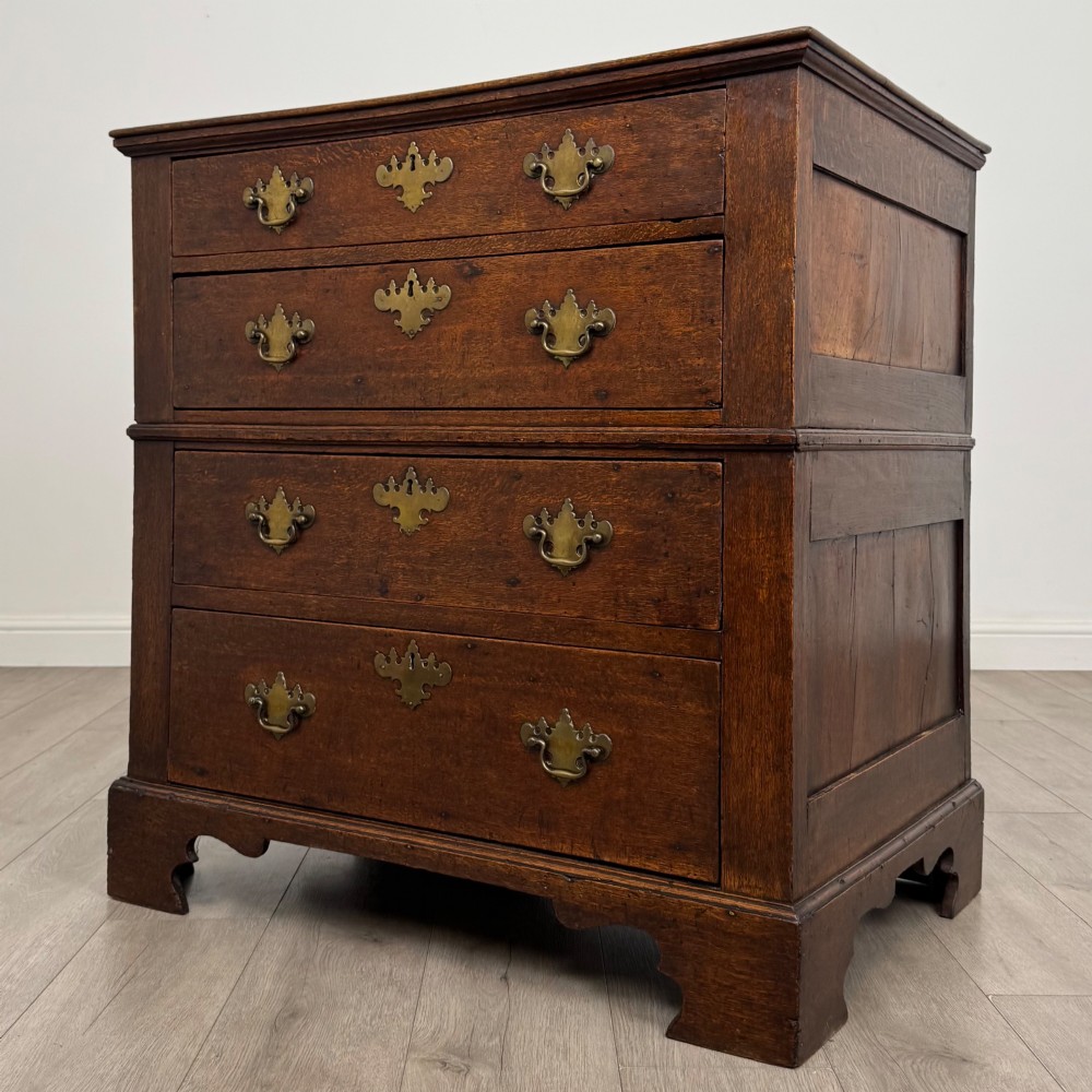 A seventeenth-century William and Mary oak chest of drawers featuring four drawers with brass escutcheons and drop handles raised on bracket feet. View II