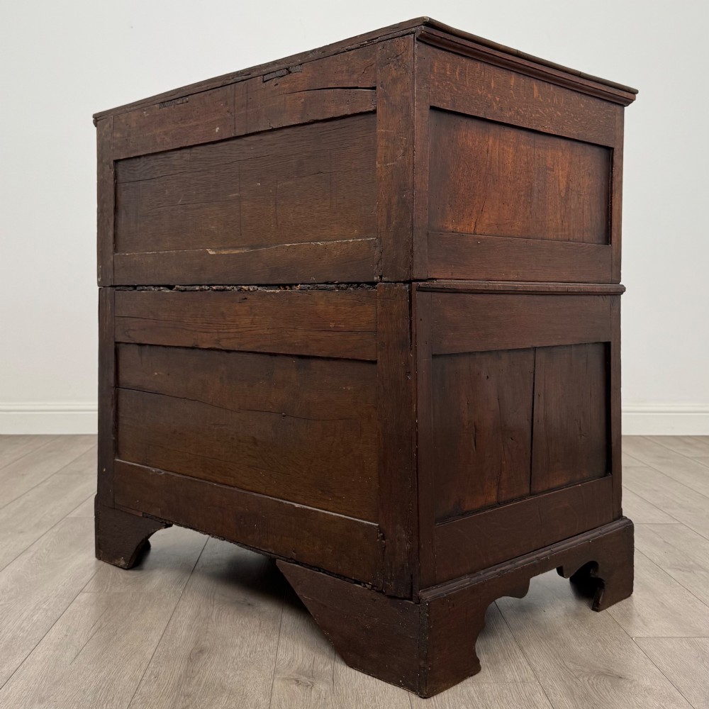A seventeenth-century William and Mary oak chest of drawers featuring four drawers with brass escutcheons and drop handles raised on bracket feet. View VI