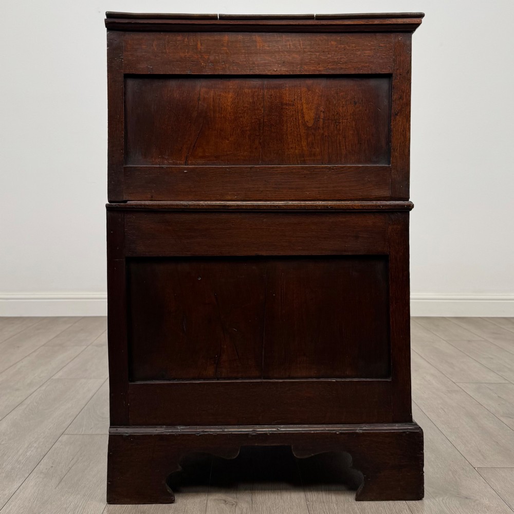 A seventeenth-century William and Mary oak chest of drawers featuring four drawers with brass escutcheons and drop handles raised on bracket feet. View VII