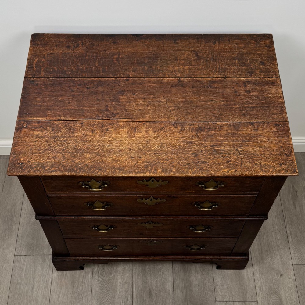 A seventeenth-century William and Mary oak chest of drawers featuring four drawers with brass escutcheons and drop handles raised on bracket feet. View IX