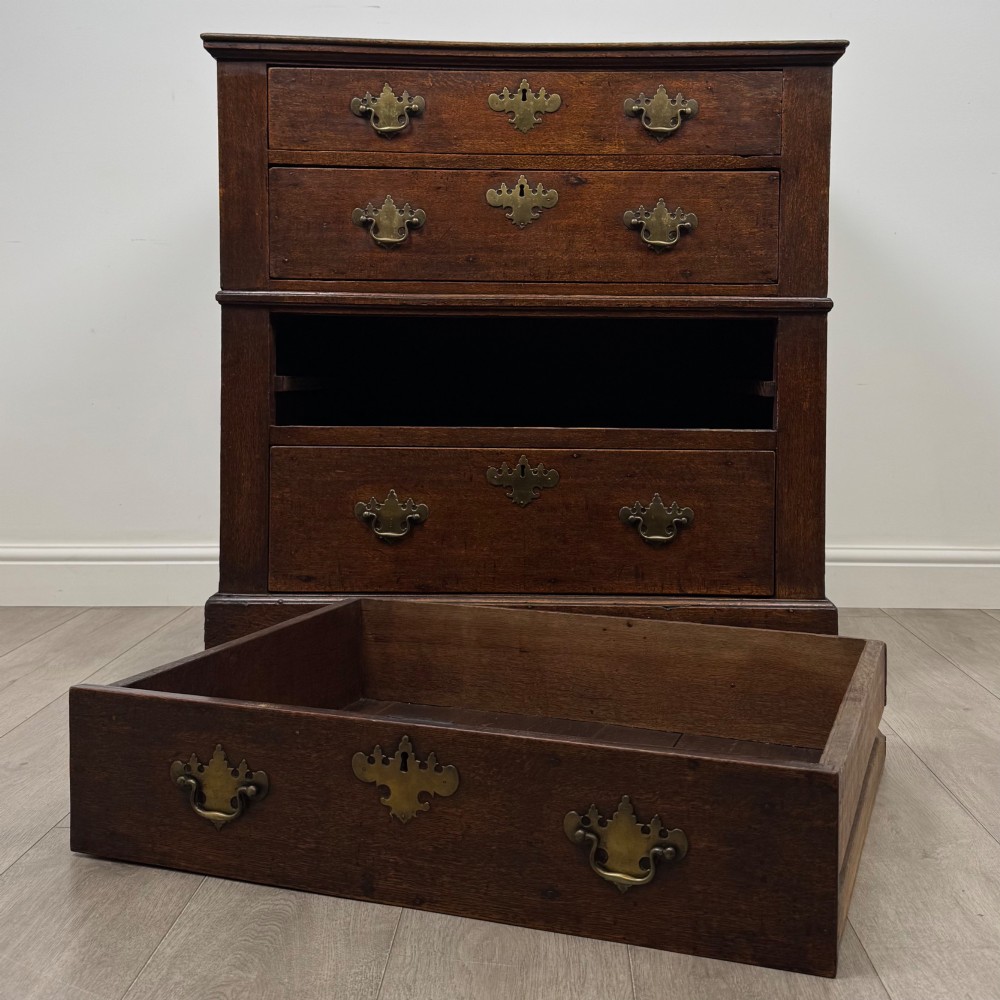 A seventeenth-century William and Mary oak chest of drawers featuring four drawers with brass escutcheons and drop handles raised on bracket feet. View X