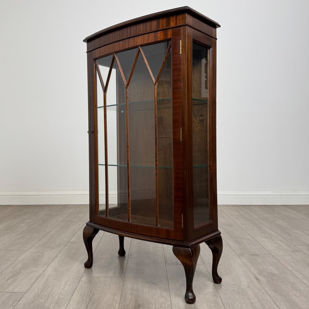 An antique mahogany display cabinet featuring a single door with geometric astragal glazing bars, glass shelves, and cabriole legs. View II