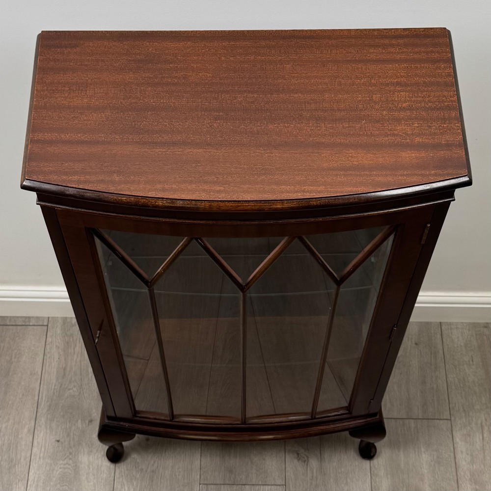 An antique mahogany display cabinet featuring a single door with geometric astragal glazing bars, glass shelves, and cabriole legs. View IX