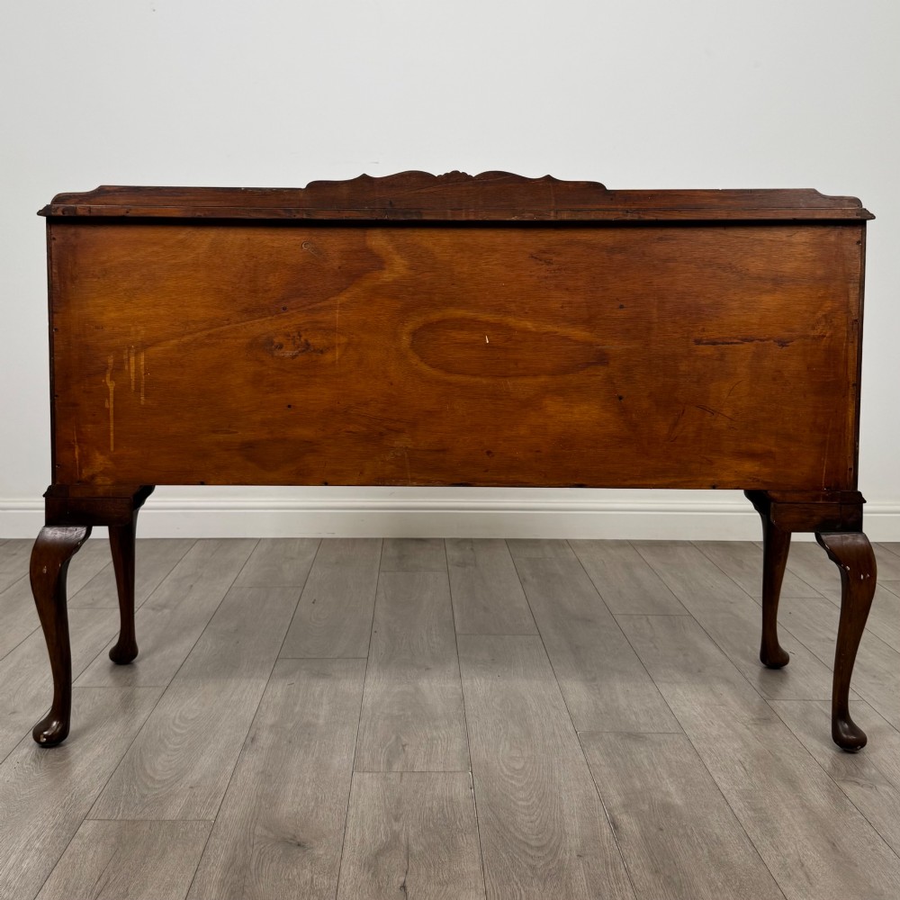 A 20th-century burr walnut sideboard featuring three central bowfront drawers flanked by cupboard doors, supported on carved cabriole legs. View VI
