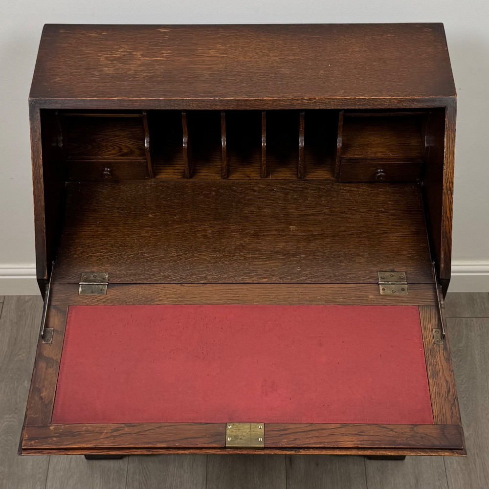 A dark oak Jacobean style slant-front bureau featuring geometric inlaid panels and four drawer fronts with turned wooden knobs. View XI
