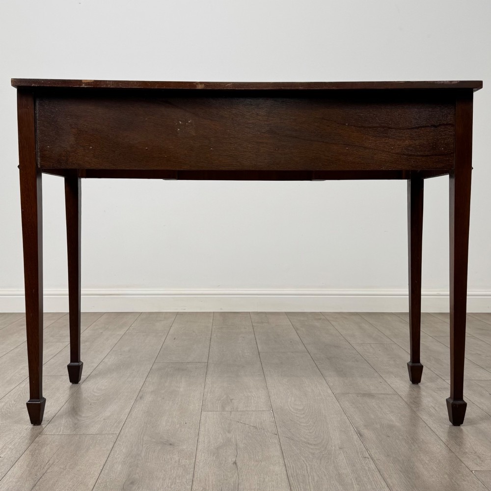 A dark mahogany 20th-century Adam style side table featuring a central carved urn motif, fluted frieze drawers, brass ring handles, and square tapered legs ending in spade feet. View V