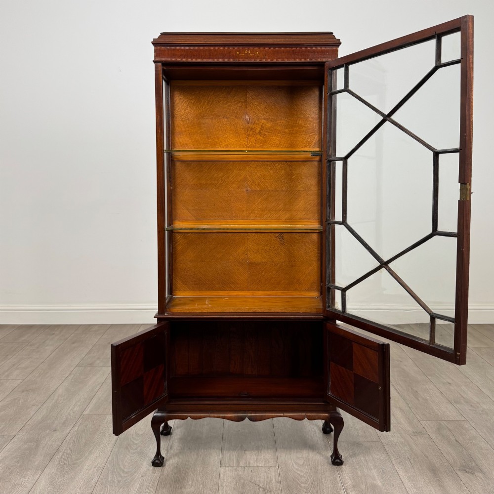 An early 20th-century mahogany glazed display cabinet featuring geometric astragal doors, marquetry inlaid lower cupboards, and cabriole legs. View II