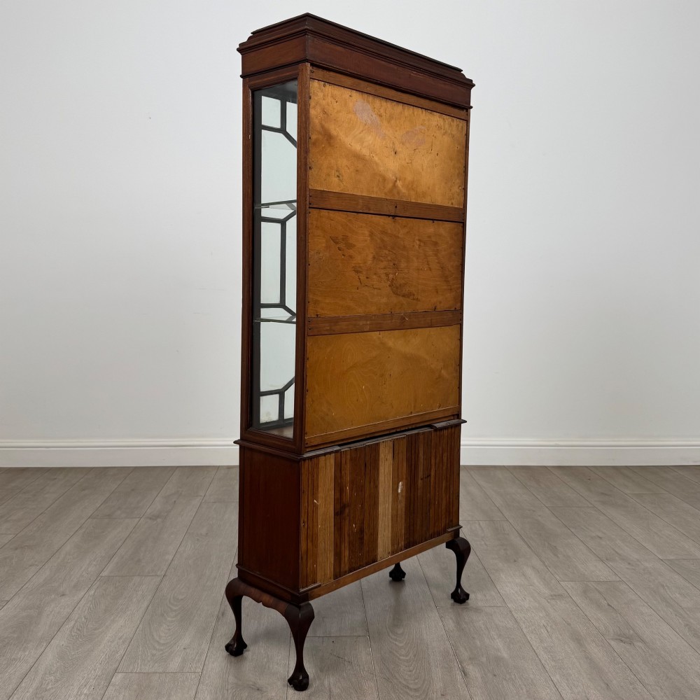An early 20th-century mahogany glazed display cabinet featuring geometric astragal doors, marquetry inlaid lower cupboards, and cabriole legs. View V