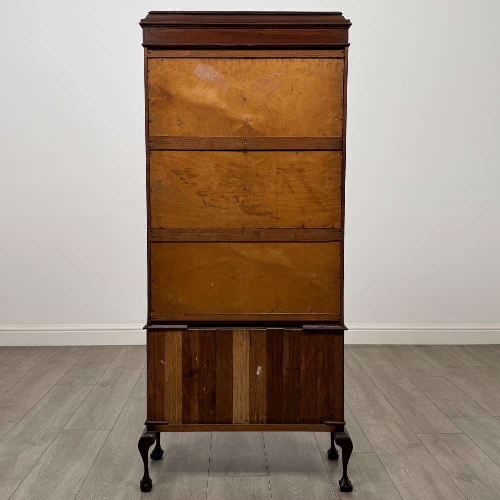 An early 20th-century mahogany glazed display cabinet featuring geometric astragal doors, marquetry inlaid lower cupboards, and cabriole legs. View VI