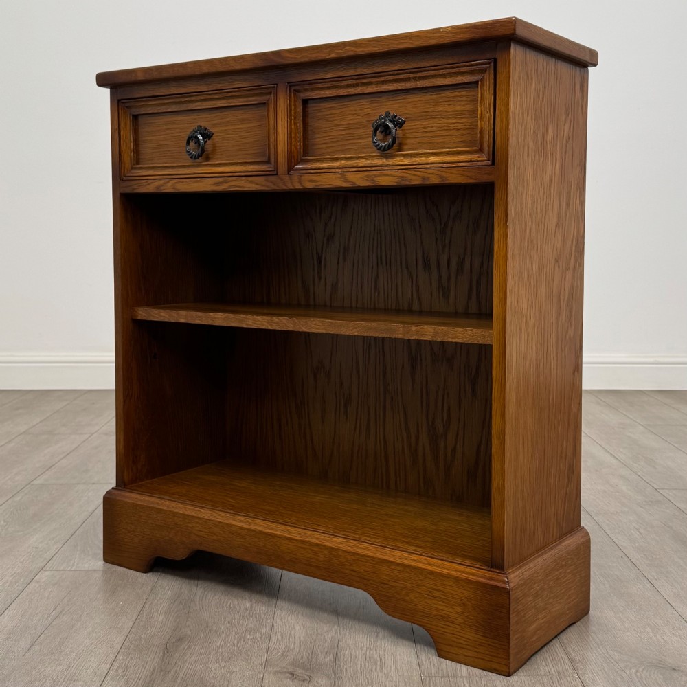 A small 20th-century open oak bookcase featuring two drawers at the top with dark twisted ring handles above two open shelves. View II