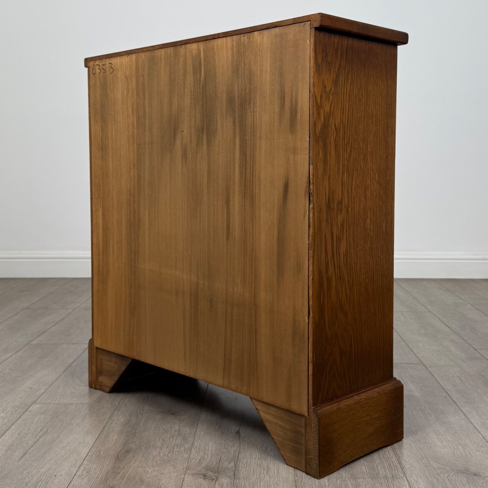 A small 20th-century open oak bookcase featuring two drawers at the top with dark twisted ring handles above two open shelves. View VI