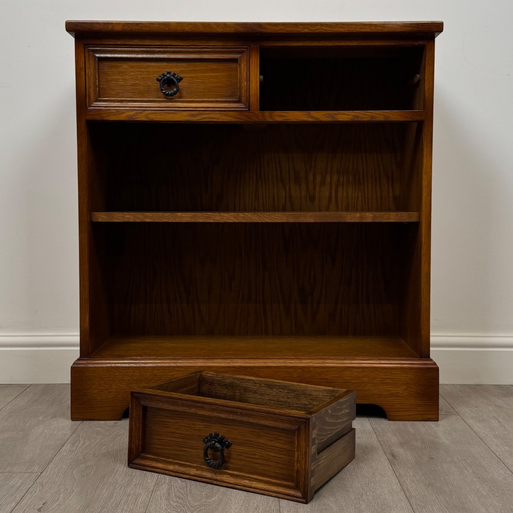 A small 20th-century open oak bookcase featuring two drawers at the top with dark twisted ring handles above two open shelves. View X