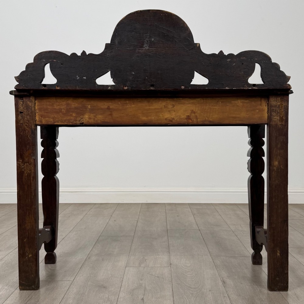 A dark carved oak Victorian side table featuring a sculpted mask upstand gallery, relief-carved frieze, and detailed carved legs. View V