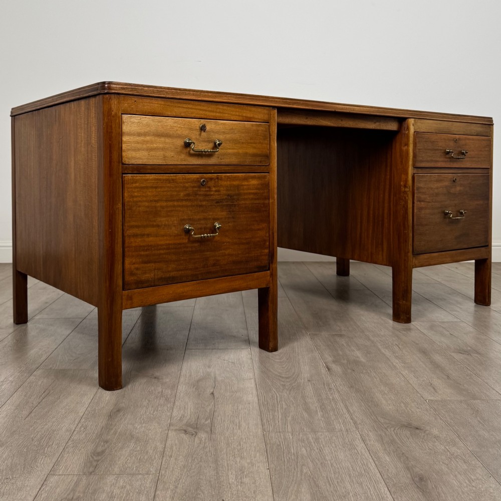 A large mid-20th century mahogany pedestal desk featuring two sets of drawers with brass drop handles and a central kneehole. View VIII