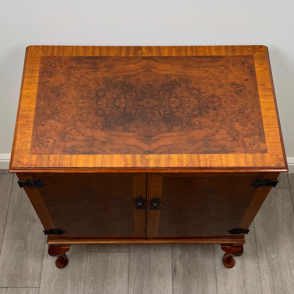 A 20th-century burr walnut two-door fitted cabinet on cabriole legs with carved shell knees and decorative pierced brass hinges. View X