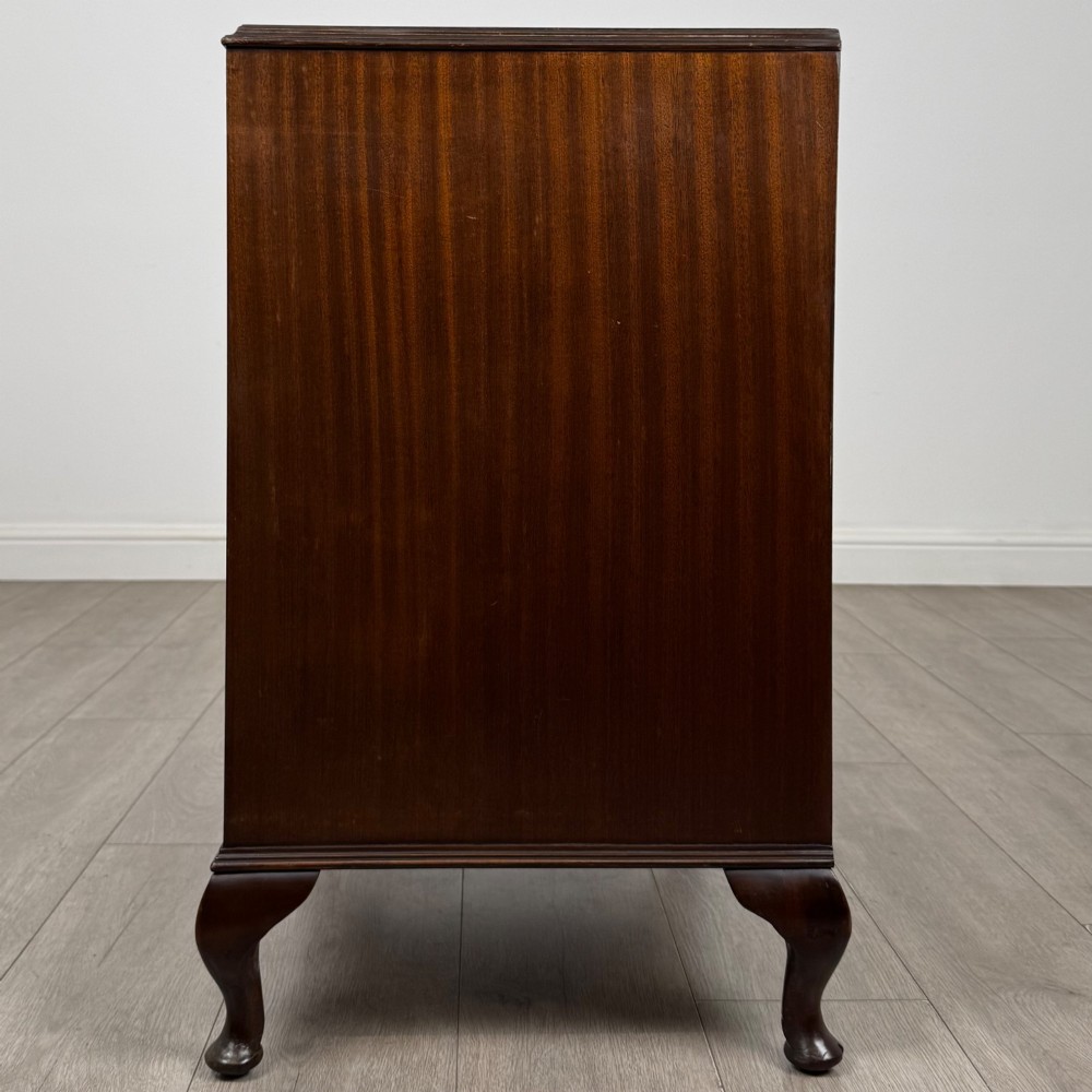 A mahogany chest of drawers featuring four full-width drawers with flame veneer fronts, brass handles, and cabriole legs. View III