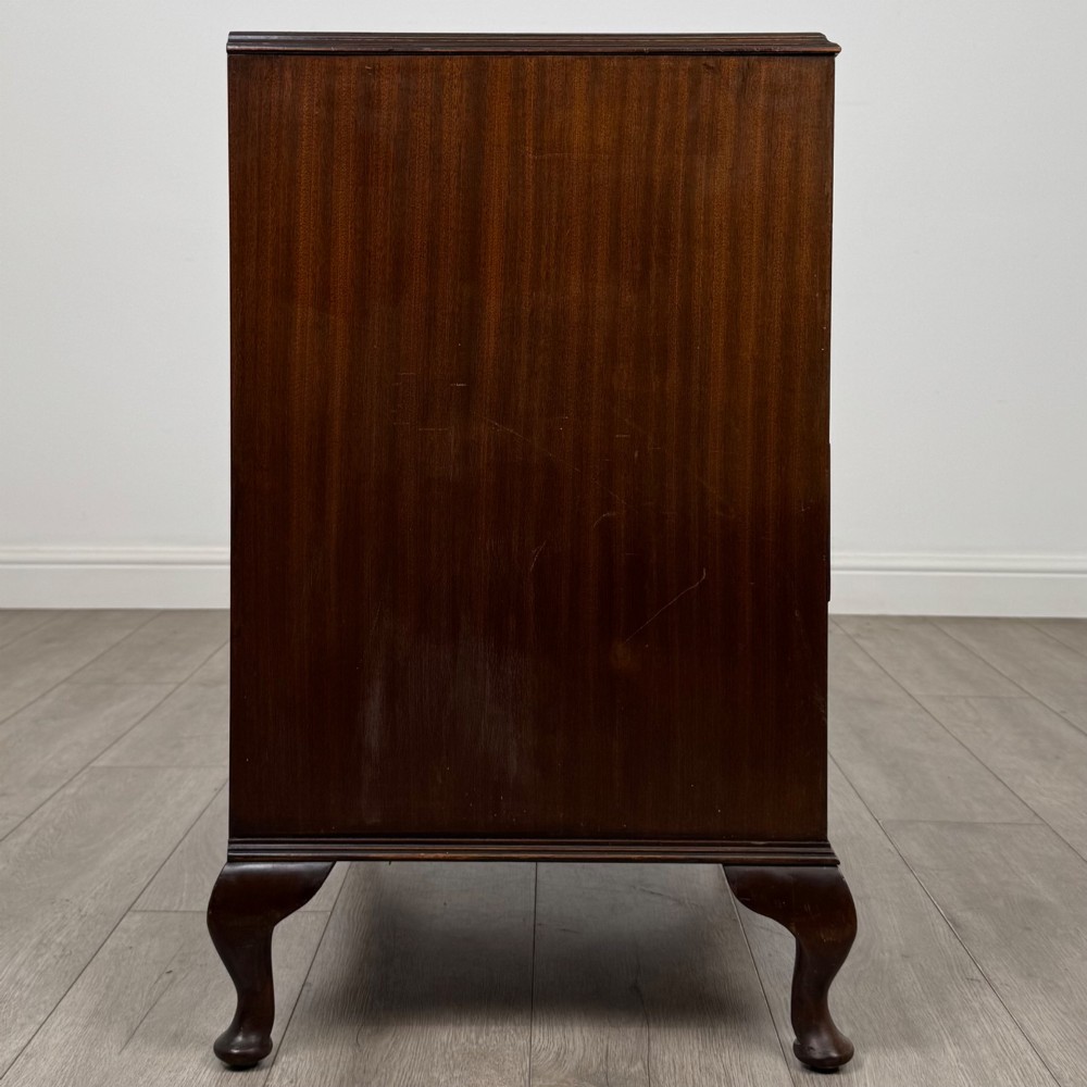 A mahogany chest of drawers featuring four full-width drawers with flame veneer fronts, brass handles, and cabriole legs. View VII