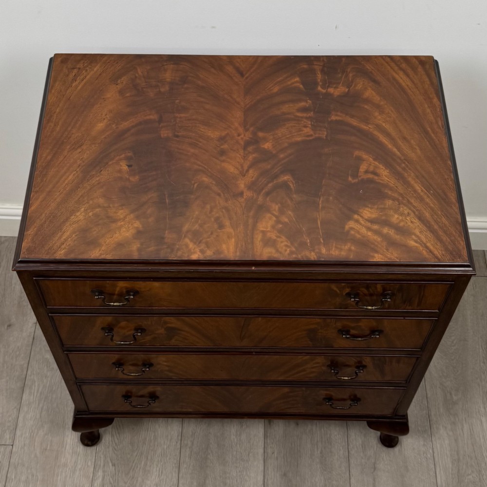 A mahogany chest of drawers featuring four full-width drawers with flame veneer fronts, brass handles, and cabriole legs. View IX