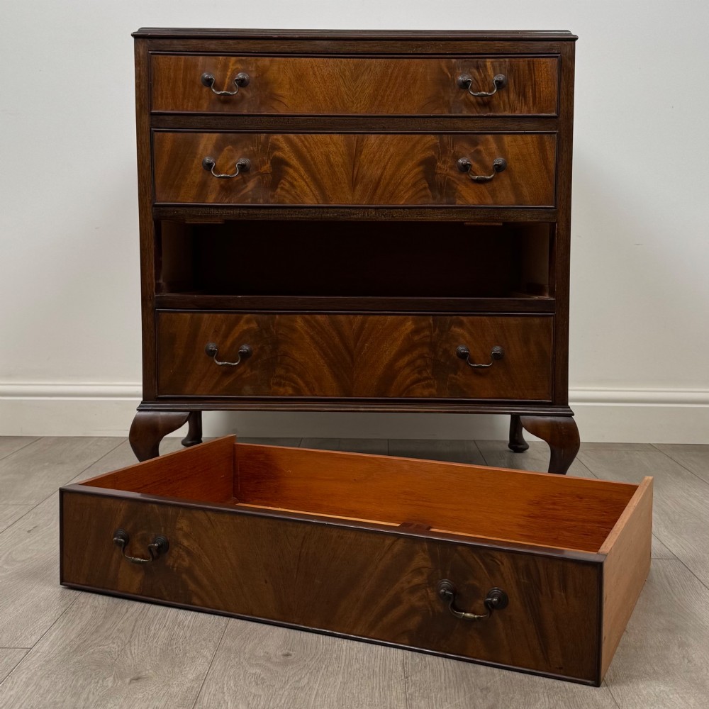 A mahogany chest of drawers featuring four full-width drawers with flame veneer fronts, brass handles, and cabriole legs. View X