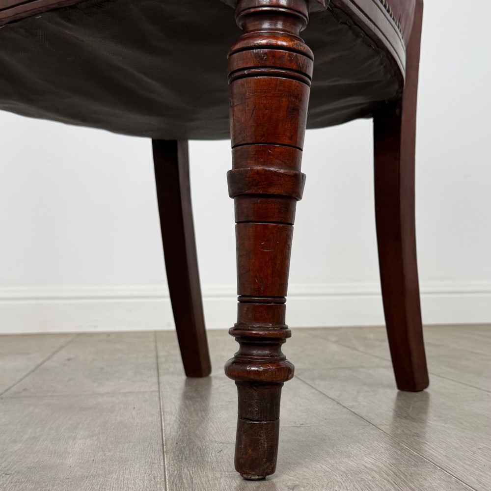 A set of four 19th-century mahogany dining chairs featuring carved open backs, dark red leather upholstered seats with stud trim, and turned front legs. View VI