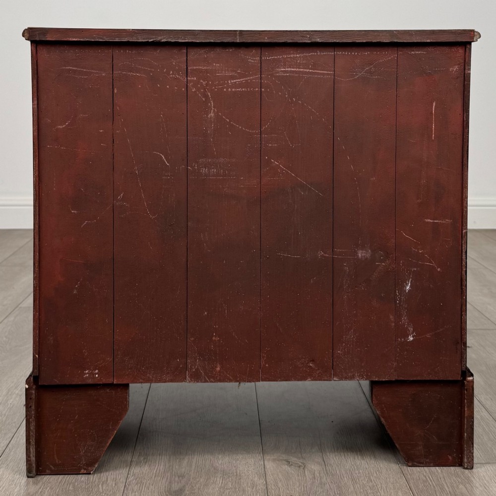 An antique oak chest of drawers featuring two short over three long drawers with brass swan-neck handles and shaped bracket feet. View V