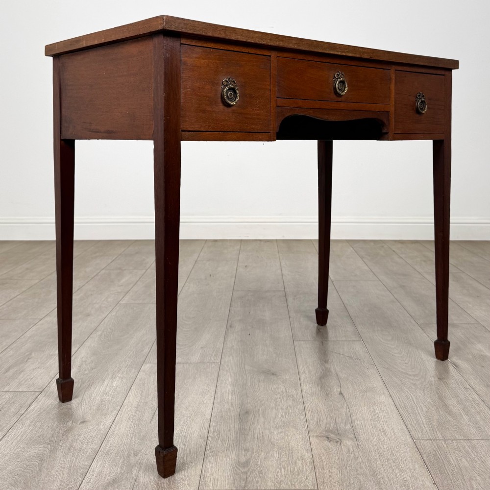 An early 20th-century mahogany writing table featuring three drawers with decorative brass ring handles and square tapered legs. View VIII