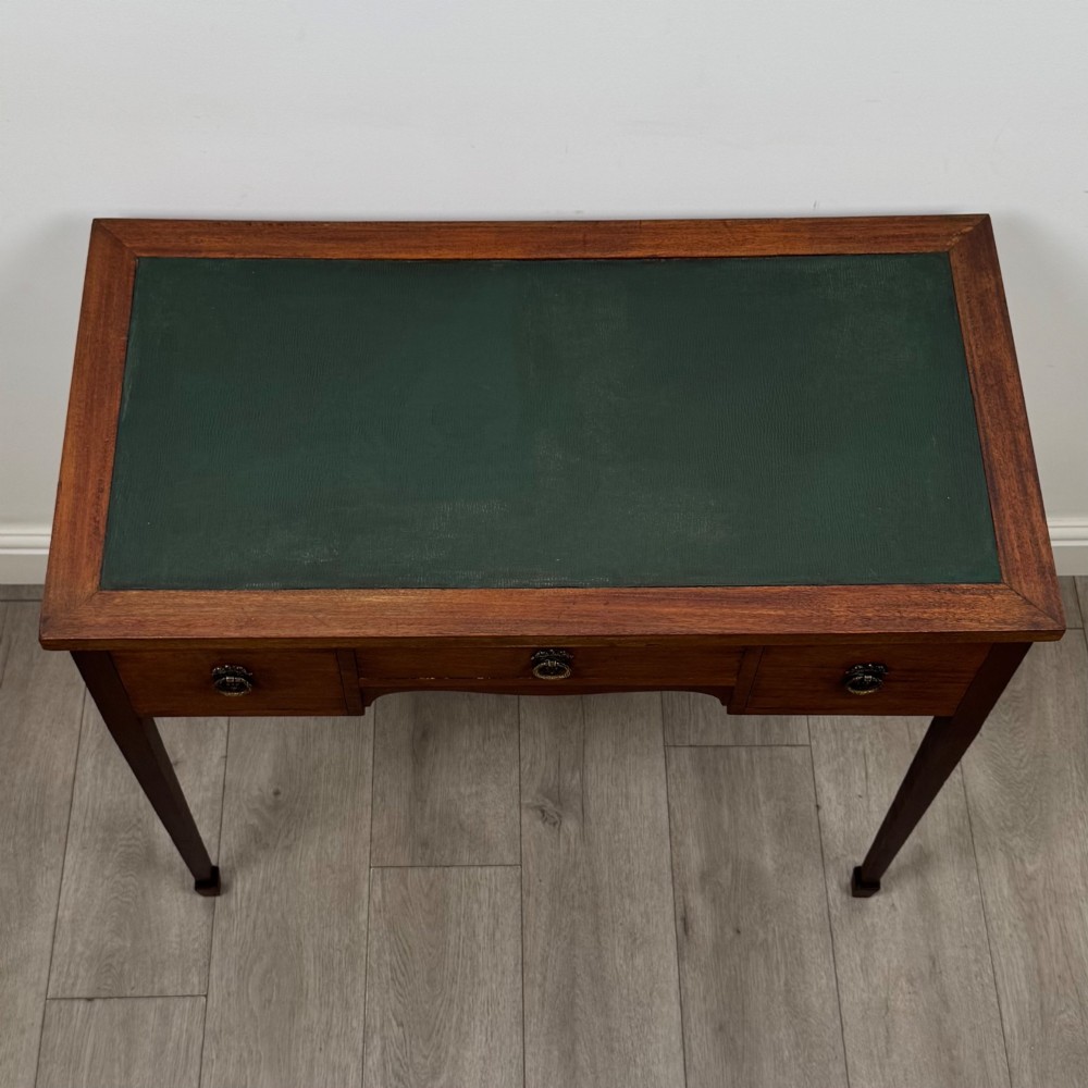 An early 20th-century mahogany writing table featuring three drawers with decorative brass ring handles and square tapered legs. View IX