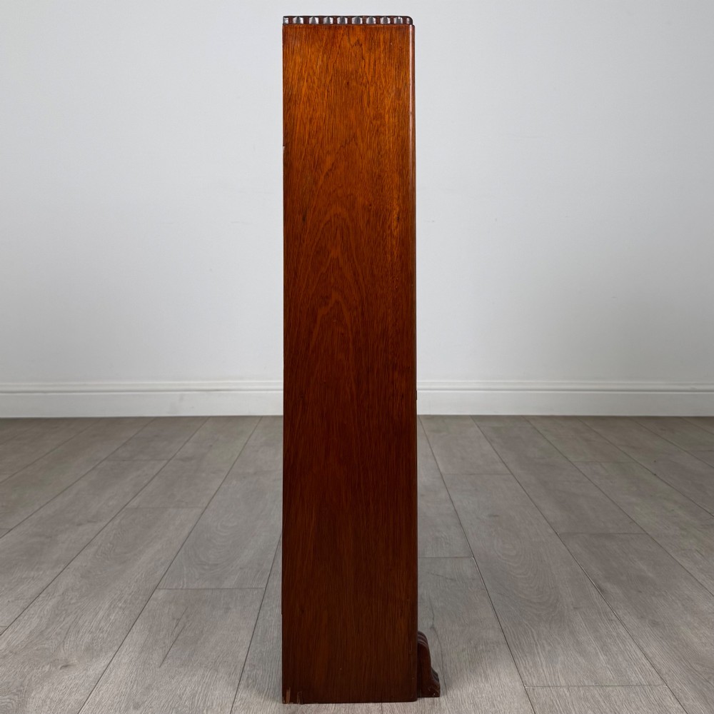 An antique narrow mahogany open bookcase featuring three tiers, a gadrooned top edge, and carved bracket feet. View VIII