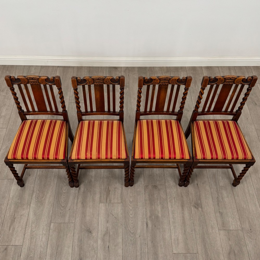 A set of six dark oak dining chairs featuring barley twist legs and stretchers with red and gold striped fabric seats. View VIII