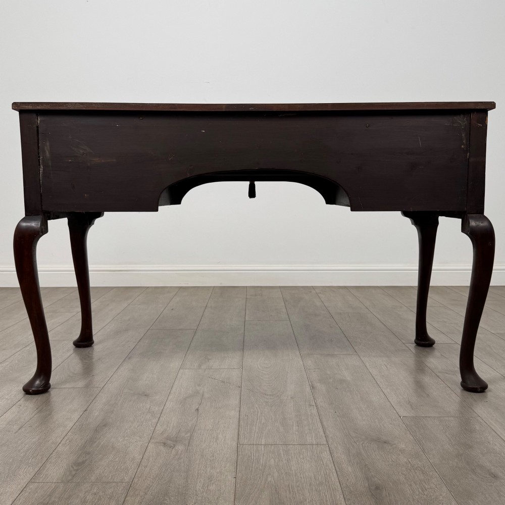 An Edwardian mahogany writing table with cabriole legs, carved knee detailing, three drawers with ornate brass handles, and a central arched kneehole. View V